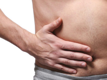 Man holding hernia on stomach